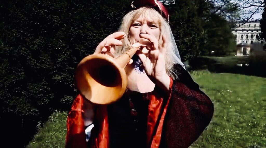 Christiane spielt im Mittelalterkostüm Schalmei.